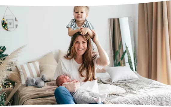 Mother and child sitting on bed